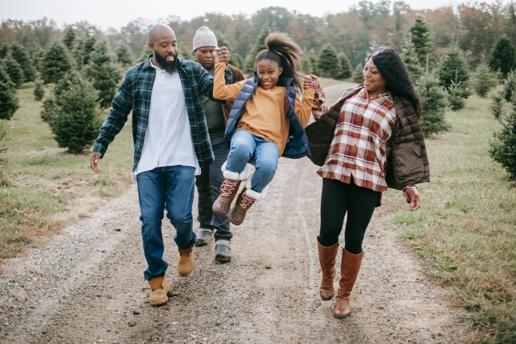 Family walking down a road surrounded by trees