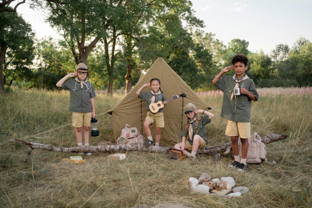 Boy scouts building a tent outdoors