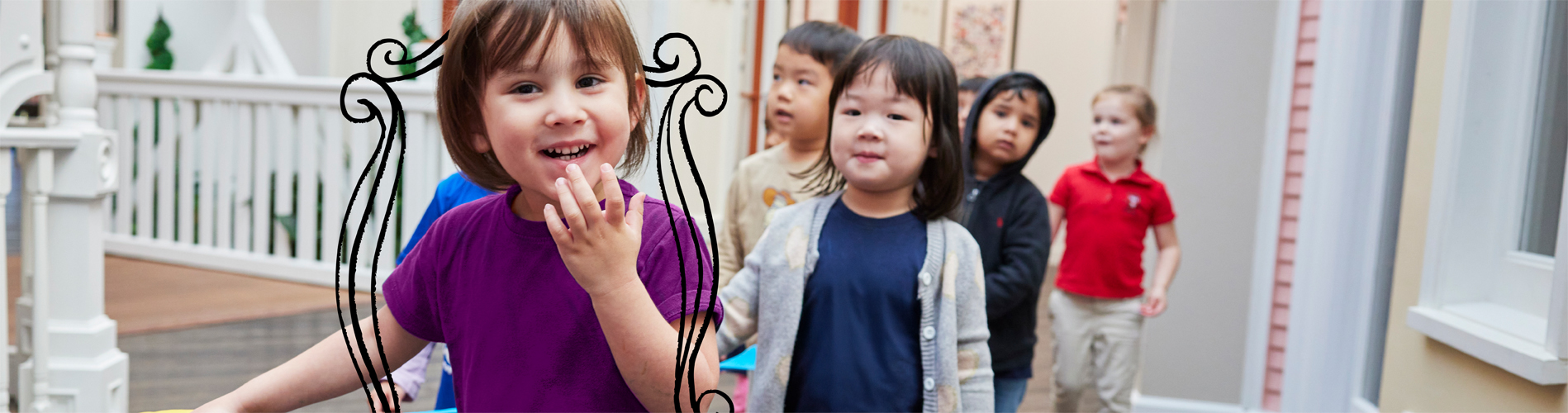 A young girl in a grey shirt kicking a soccer ball on a field during an outdoor summer camp game with other kids.