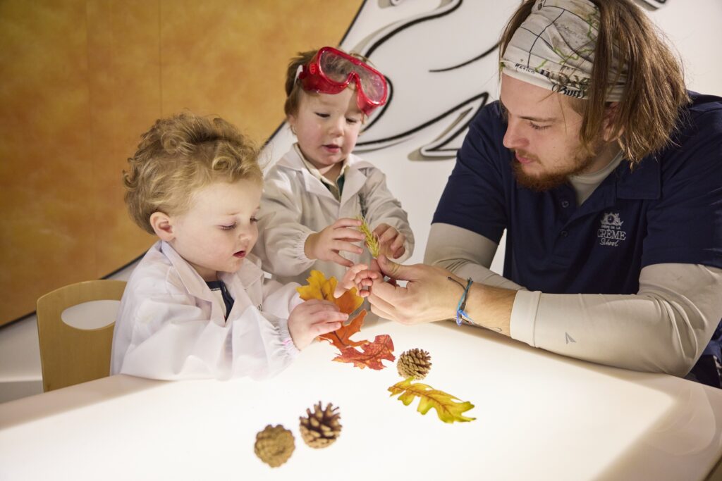 Kids and teacher inspecting leaves after a nature walk