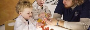 Kids and teacher inspecting leaves after a nature walk