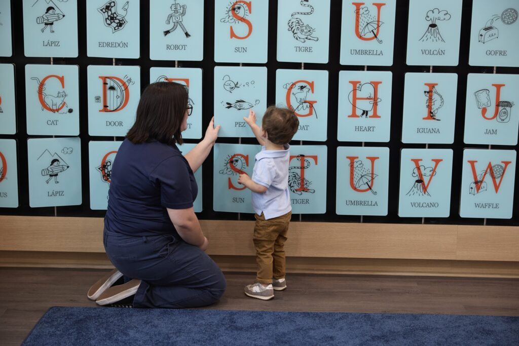 Child picking out wildlife on a alphabet chart with teacher