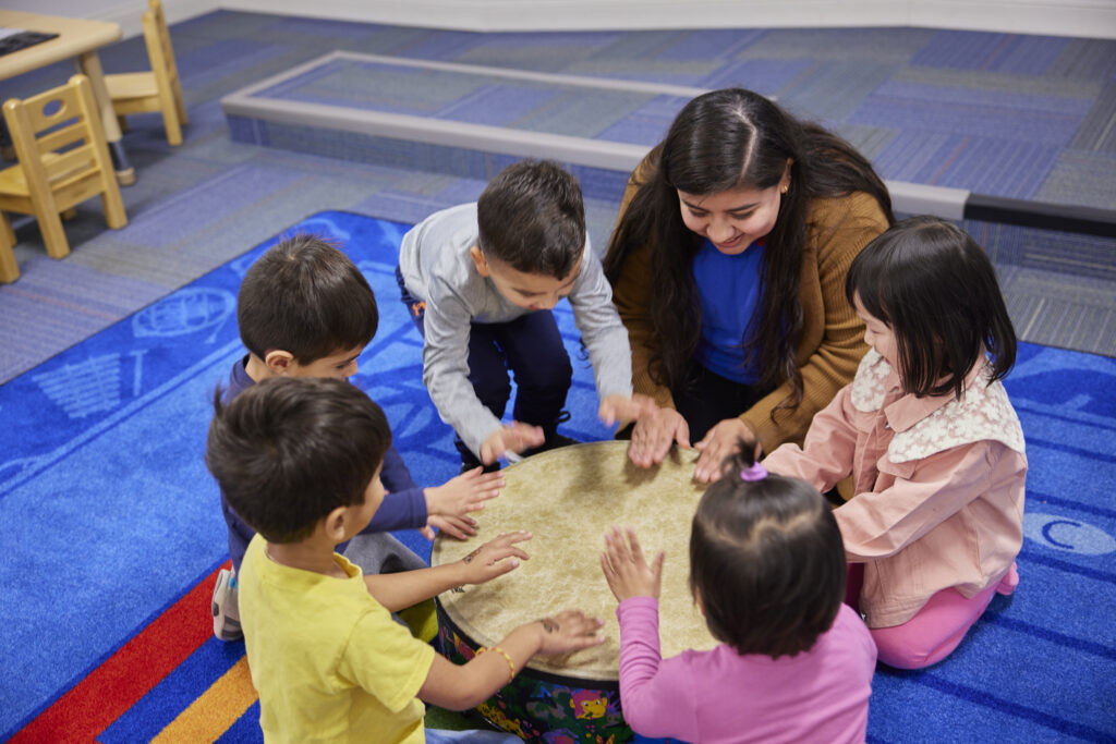 Children and teacher around a drum