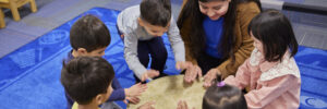 Children and teacher around a drum