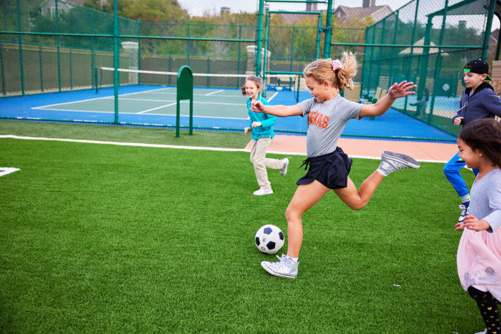 Young girl playing soccer outdoors