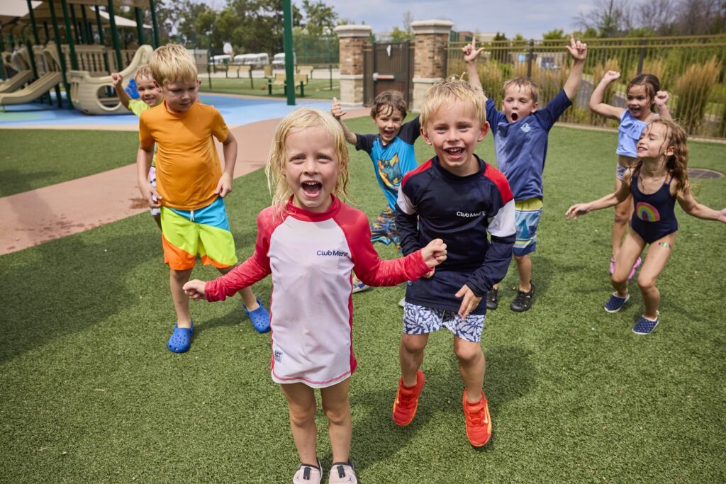 Children playing outdoors near a playground