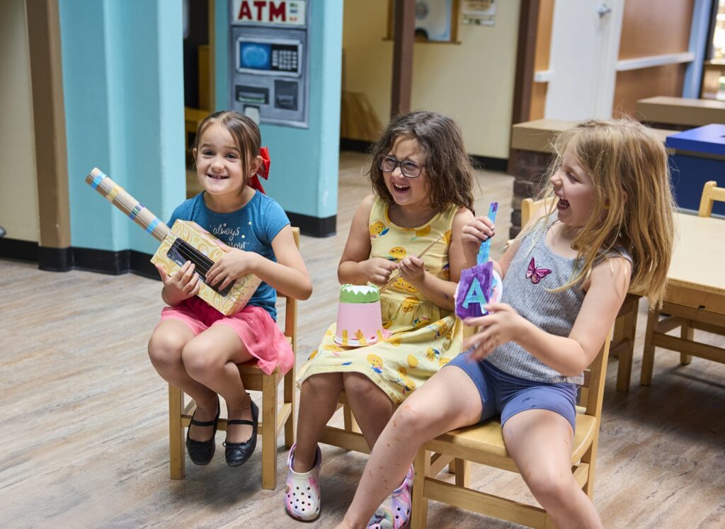 3 Children playing instruments and laughing