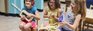 3 Children playing instruments and laughing