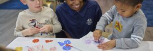 Teacher and two children doing arts and crafts