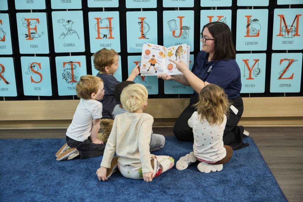 Children with teacher reading a book to them