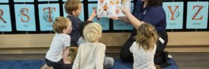 Children with teacher reading a book to them