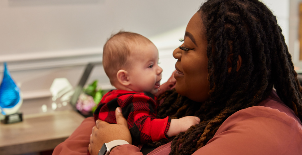 A Creme de la Creme employee with an infant at daycare