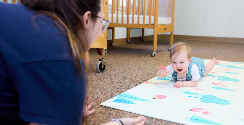 A Creme de la Creme employee with an infant at daycare
