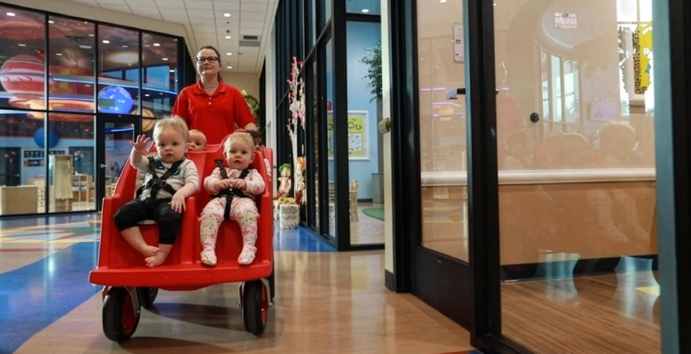 A Creme de la Creme employee with an infant at daycare