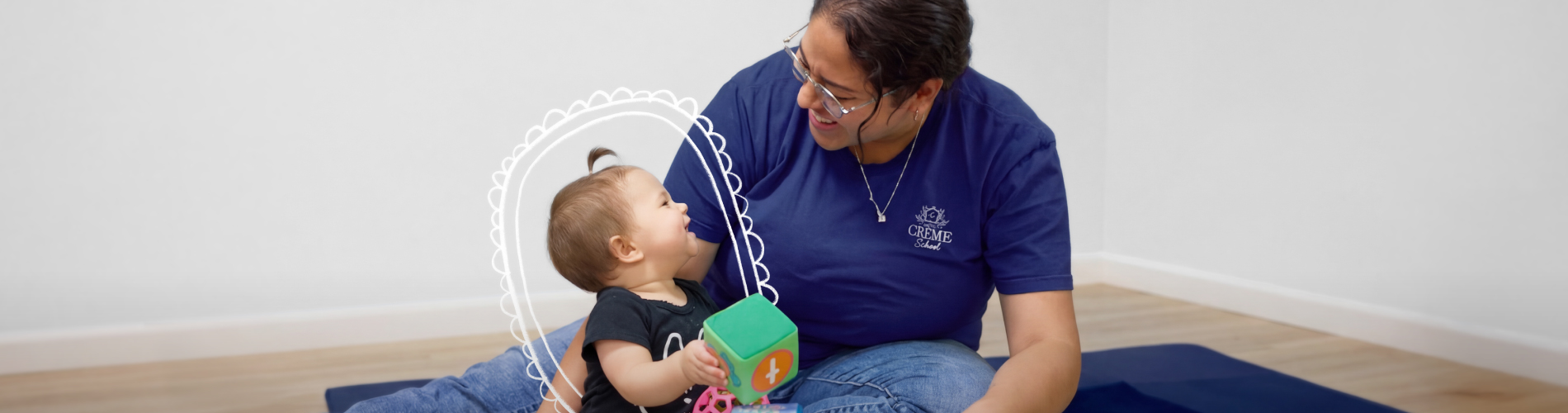 Two caregivers, holding and looking after infants at Crème School infant daycare.