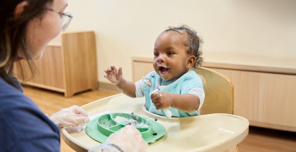 A Creme de la Creme employee with an infant at daycare