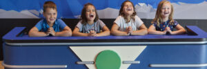 Children sitting at a game show table laughing