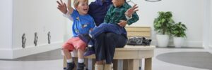 Teacher and two students happy and smiling in preschool lobby