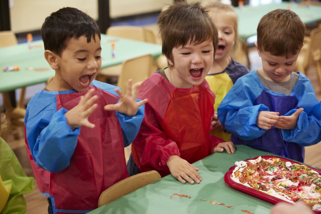 3 children at a table happy and playing