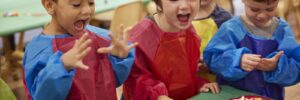 3 children at a table happy and playing